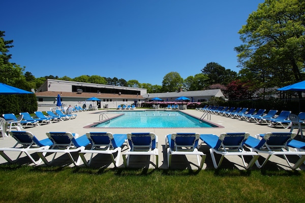Een binnenzwembad, een buitenzwembad, ligstoelen bij het zwembad