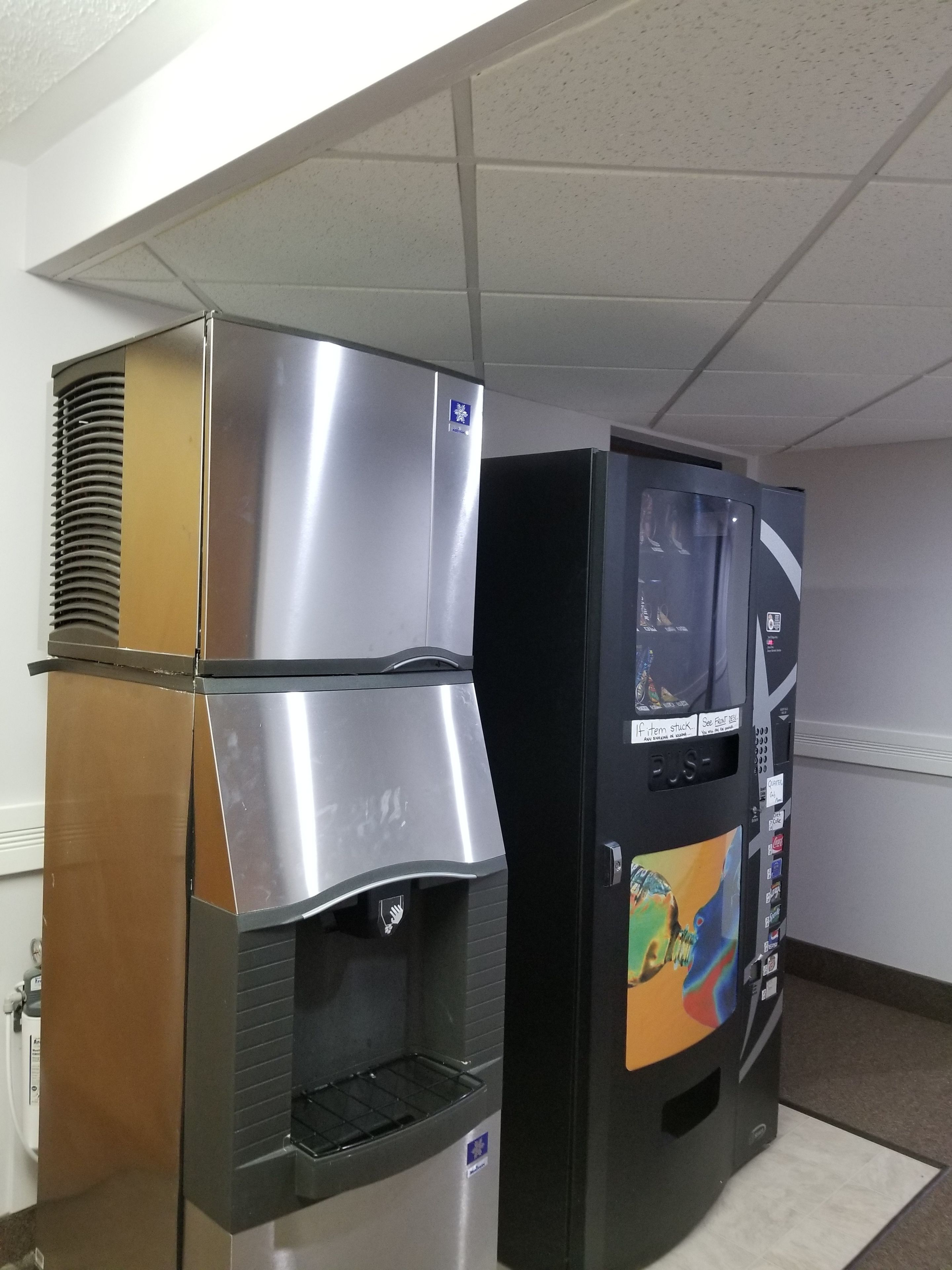 A commercial kitchen with stainless steel appliances, including a large oven and a refrigerator with a digital display.
