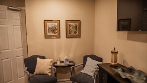 A room with two armchairs, a small table with a tray, and a wall-mounted TV. - The Chepstow Inn (Brockton)