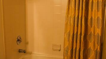 Un baño con bañera, inodoro y cortina de ducha.