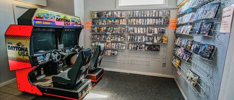 A rental arcade with a NASCAR theme, including a racing simulator and a wall of video game rentals.