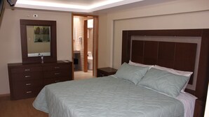Une chambre à coucher avec un grand lit, une commode à tiroirs, un miroir et une table de chevet.