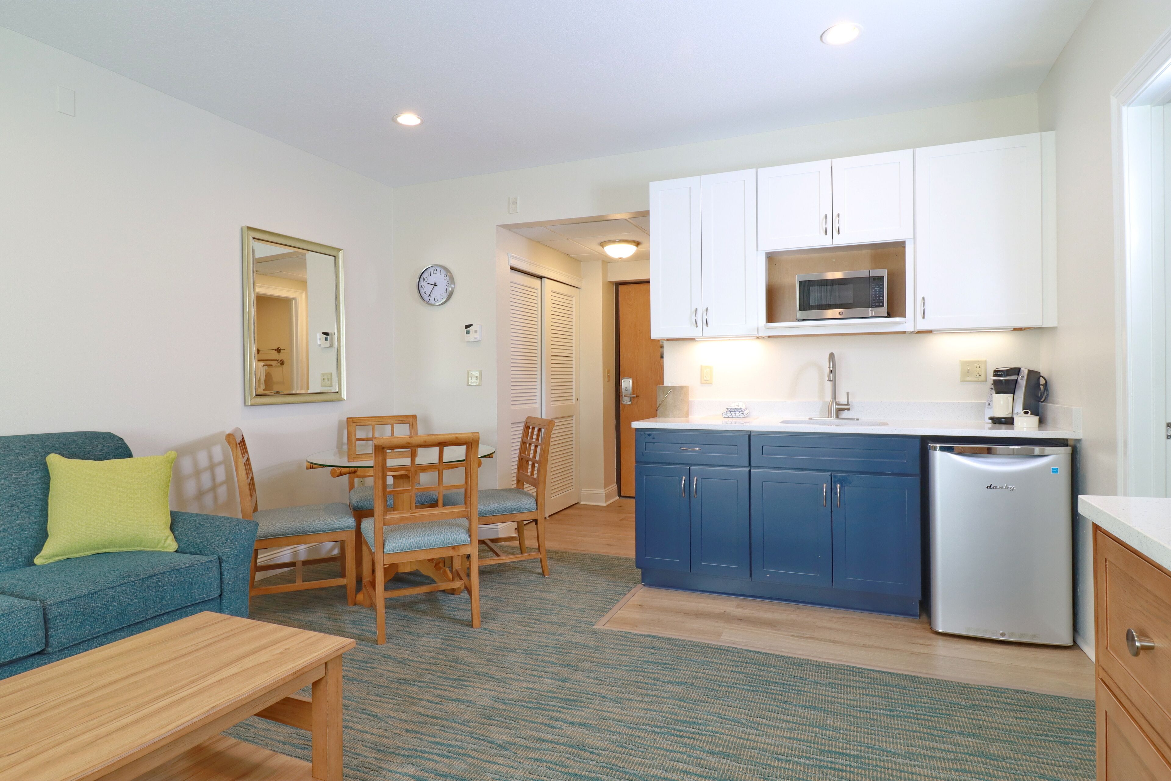 Un espacio habitable compacto con kitchenette, comedor y zona de estar.