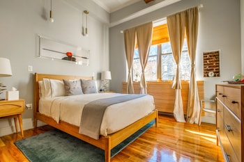 A modern kitchen with dark cabinets, a round wooden table, and two chairs. at Franklin Guesthouse