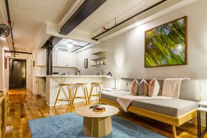 Deluxe loft, terras | Woonruimte | Een 43-inch flatscreentelevisie met kabelzenders en televisie