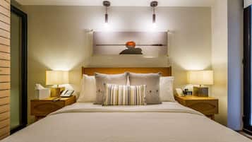 A hotel room with a large bed, two bedside tables with lamps, a telephone, and a wall-mounted artwork.