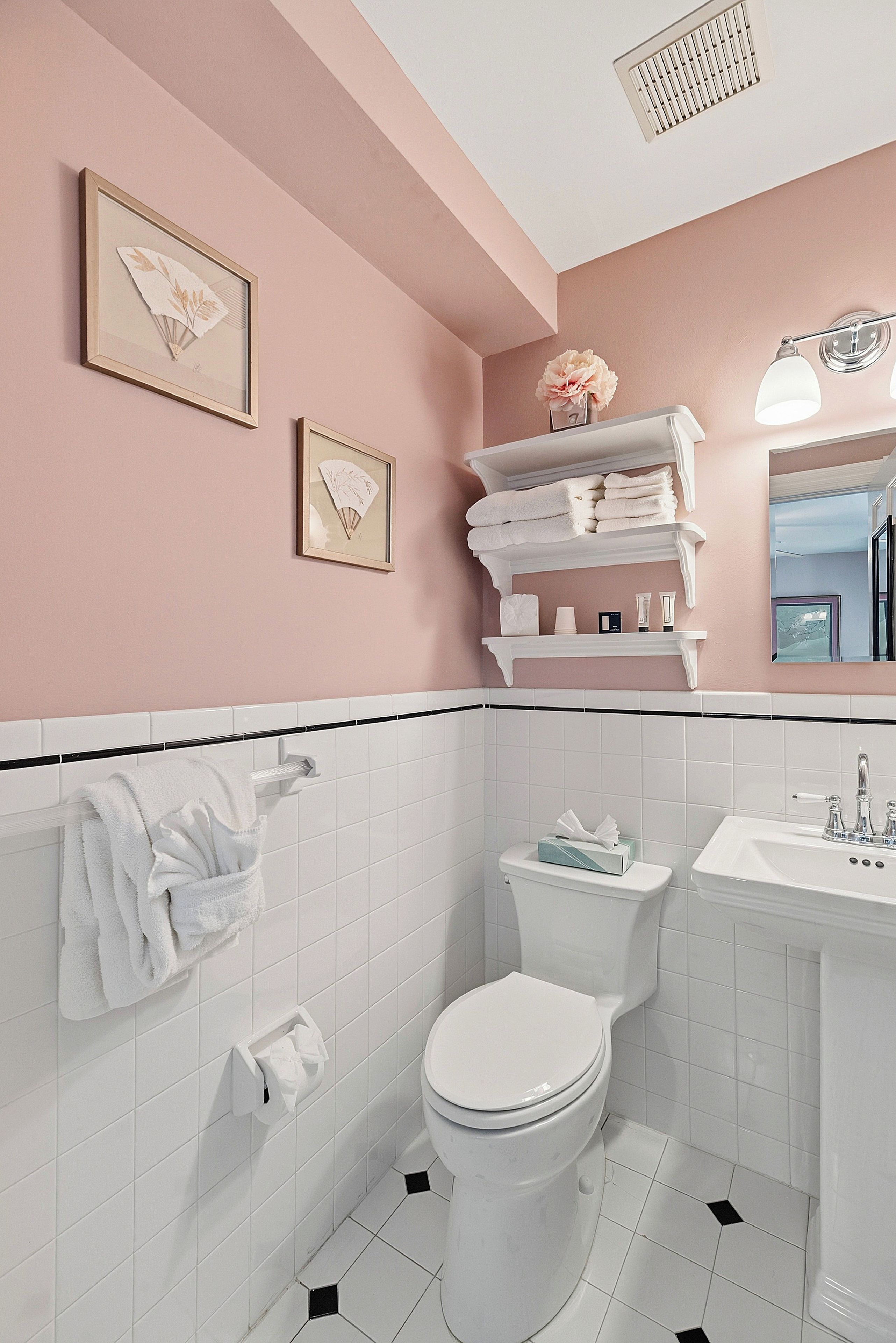 A bathroom with a toilet, sink, and towel rack.