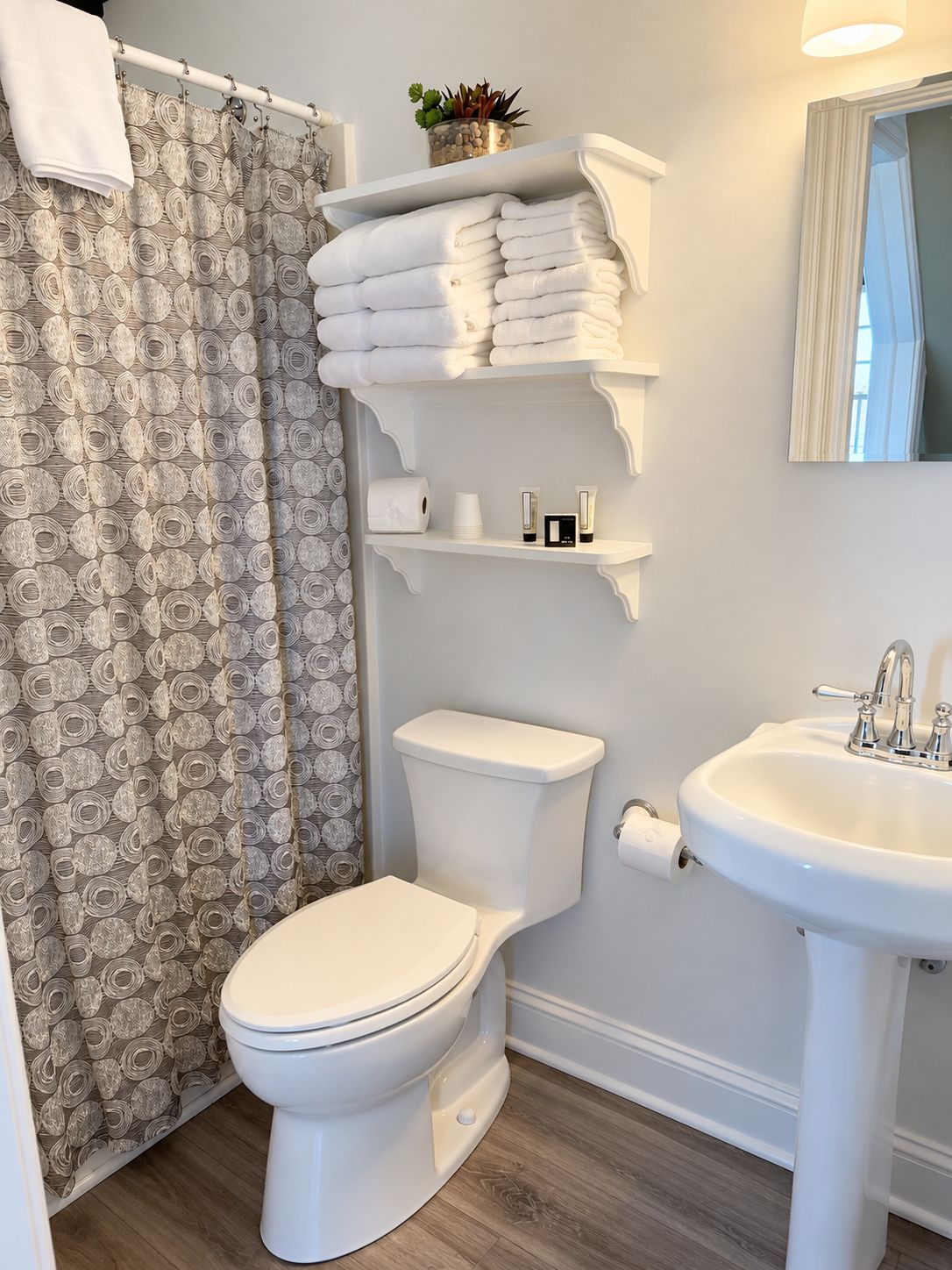 A bathroom with a toilet, sink, towel rack, and shower curtain.