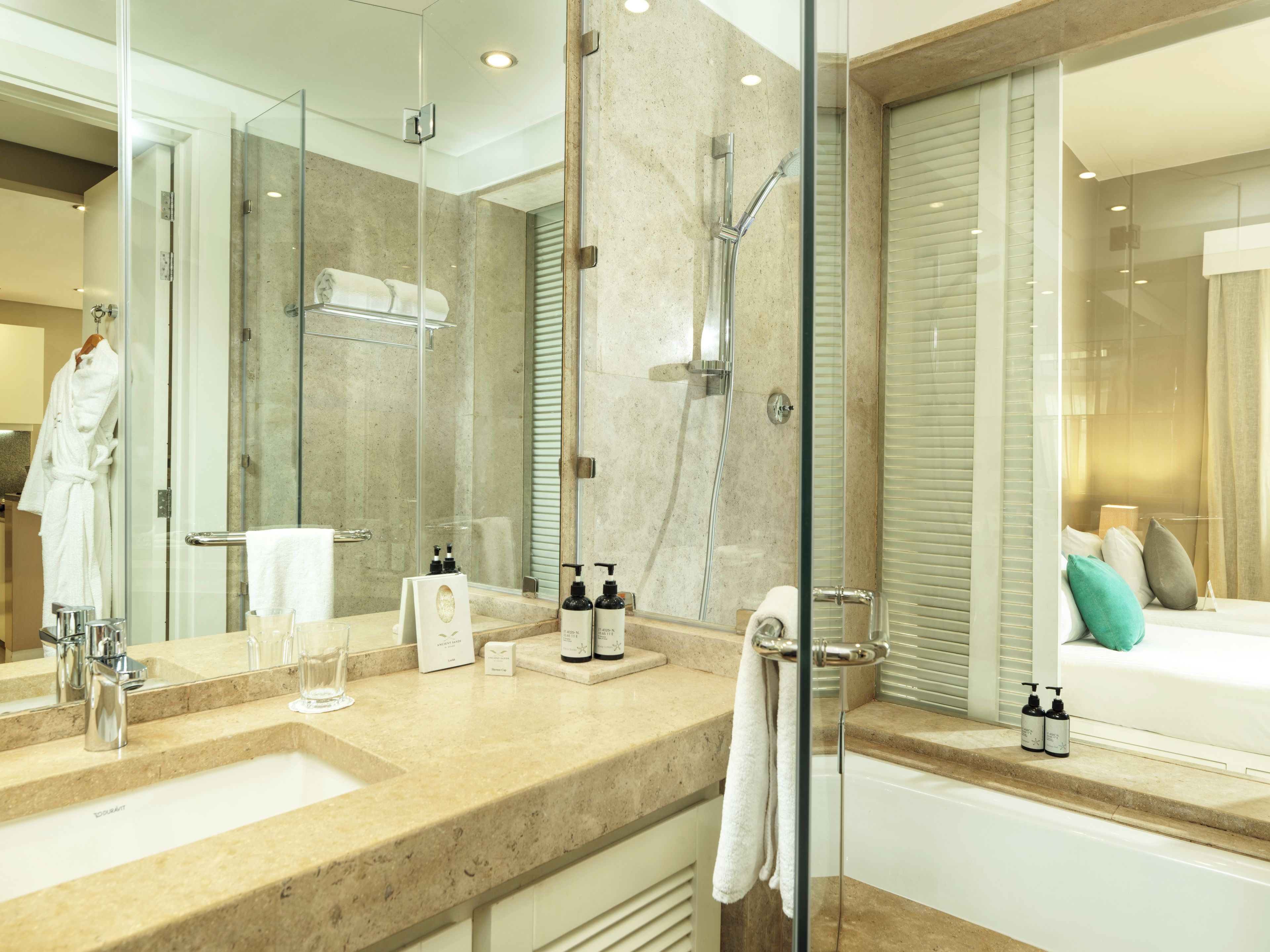 A modern bathroom with a glass shower enclosure, a bathtub, and a vanity with a mirror.