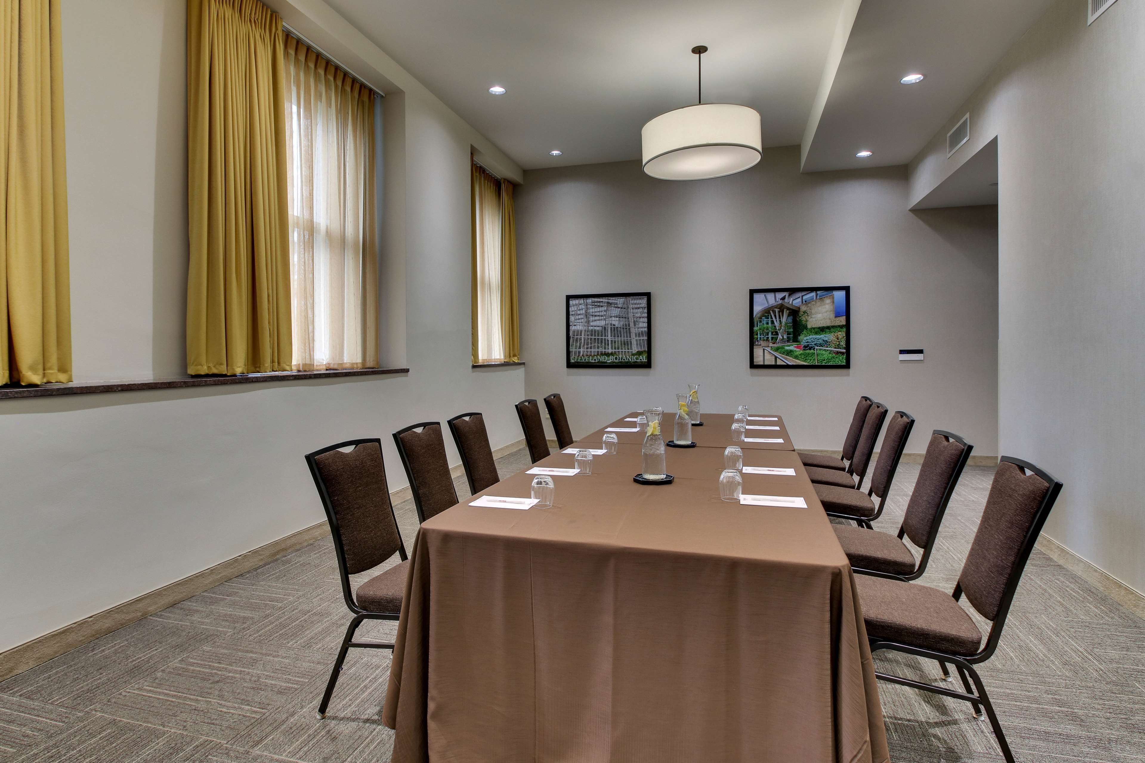 A conference room with a long table, chairs, and a chandelier.