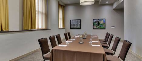 A conference room with a long table, chairs, and a chandelier.