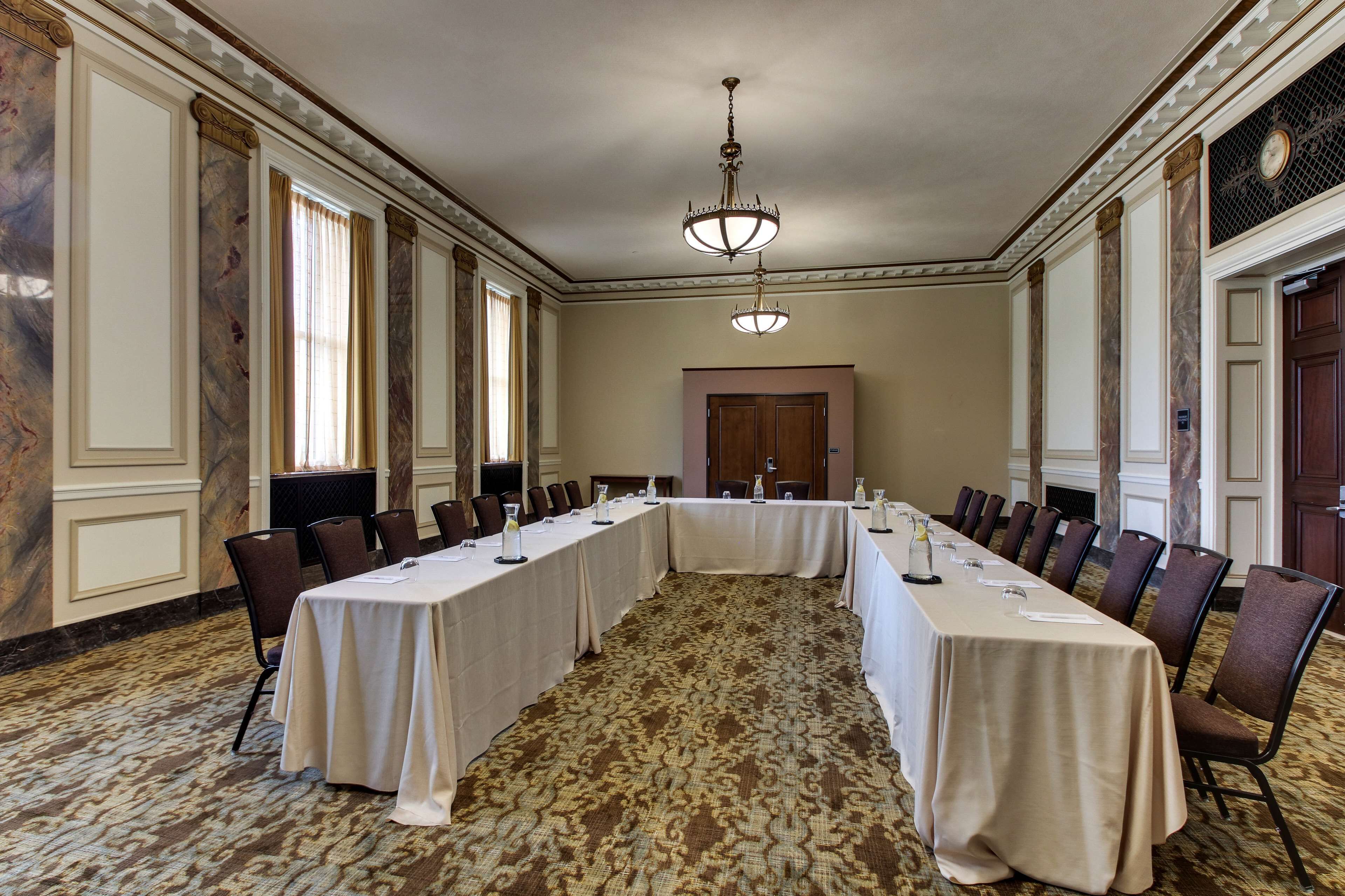 A conference room with a long table, chairs, and a chandelier.