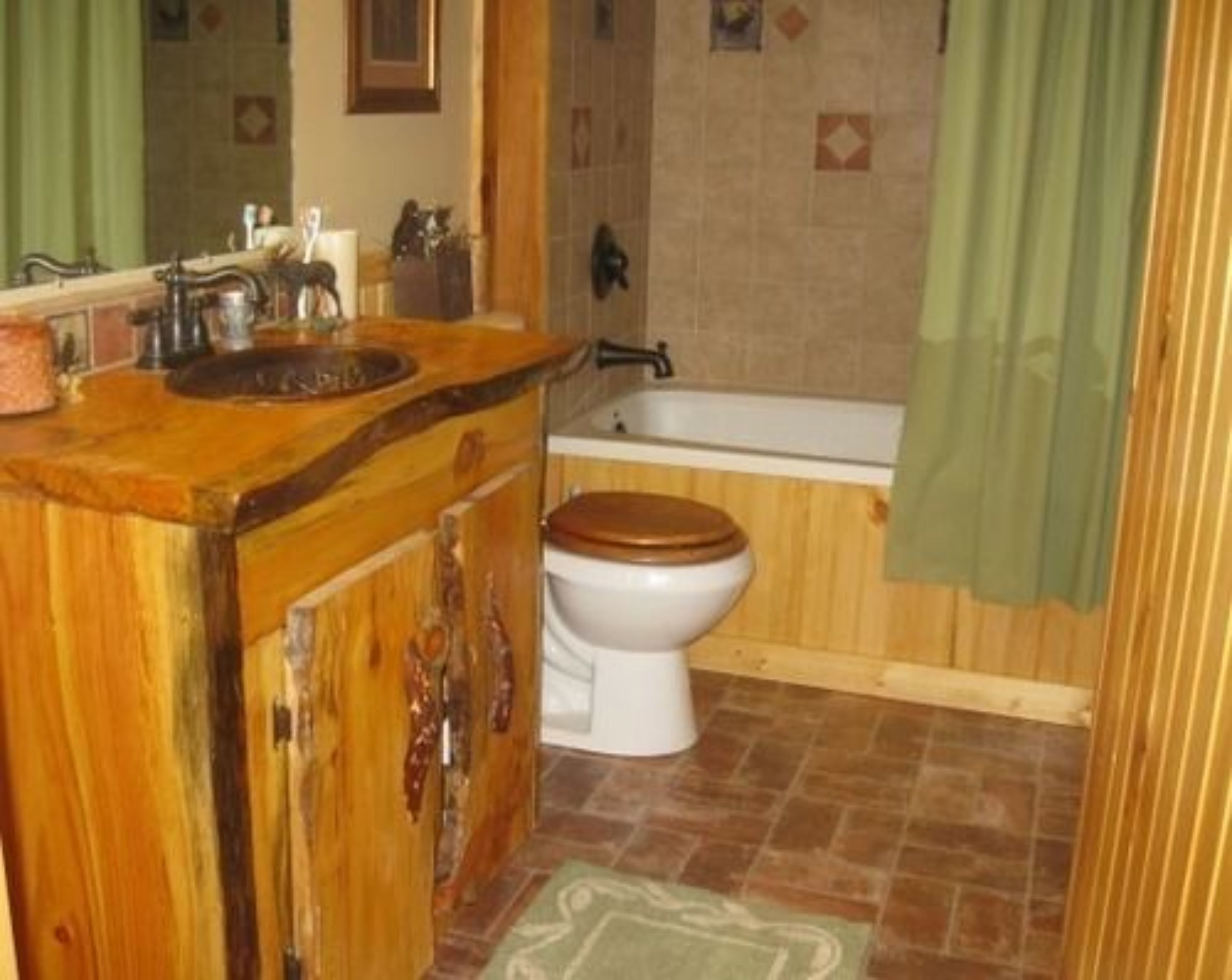 A bathroom with a wooden vanity, a white toilet, and a bathtub.