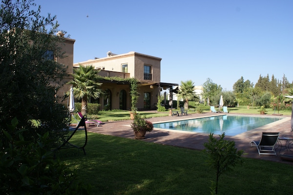 Una piscina al aire libre, sillones reclinables de piscina