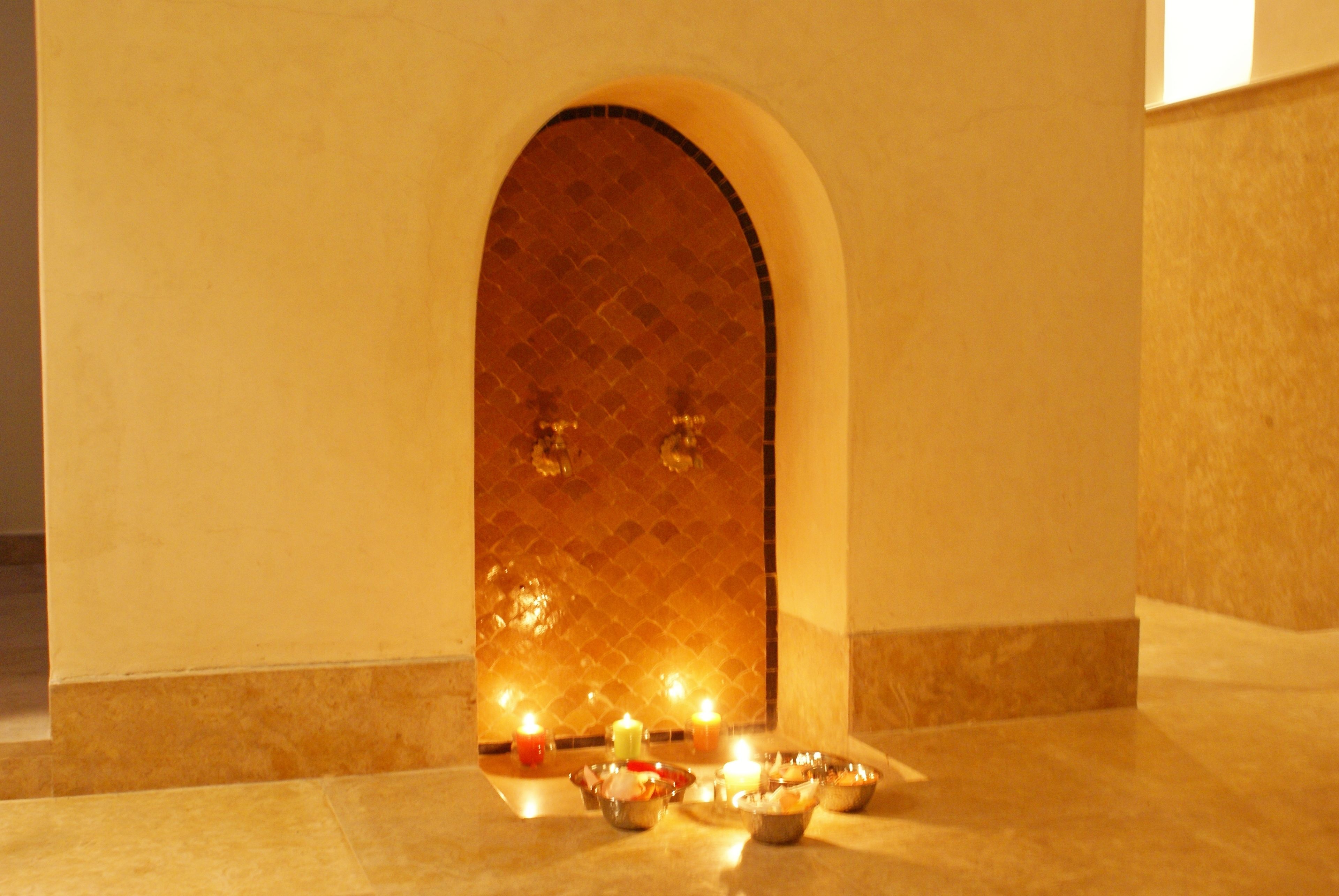 An arched doorway with a tiled interior, leading to a room with a tiled floor.