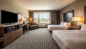 A hotel room with a flat-screen TV, two beds, a desk with a lamp, a sofa, and a large window with curtains. - Holiday Inn Portland West - Hillsboro by IHG (Hillsboro)