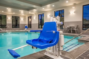 A poolside area with a blue pool chair, a pool lift, and a pool table. - Holiday Inn Portland West - Hillsboro by IHG (Hillsboro)