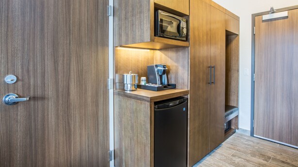 A compact kitchen with a built-in microwave, coffee maker, and dishwasher.