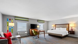 Ein Hotelzimmer mit einem Bett, einem Schreibtisch, einem Fernseher und einem Sessel.
