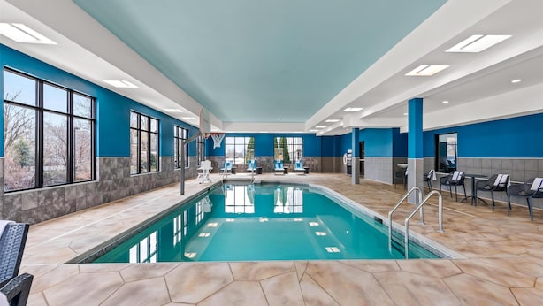 Ein Hallenbad mit klarem, blauen Wasser, umgeben von sechseckigen Fliesen.