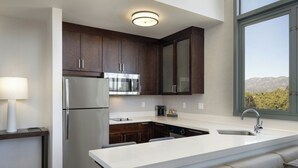 A modern kitchen with dark wooden cabinets, stainless steel appliances, and a large island with seating. - Residence Inn Los Angeles Pasadena/Old Town (Pasadena)