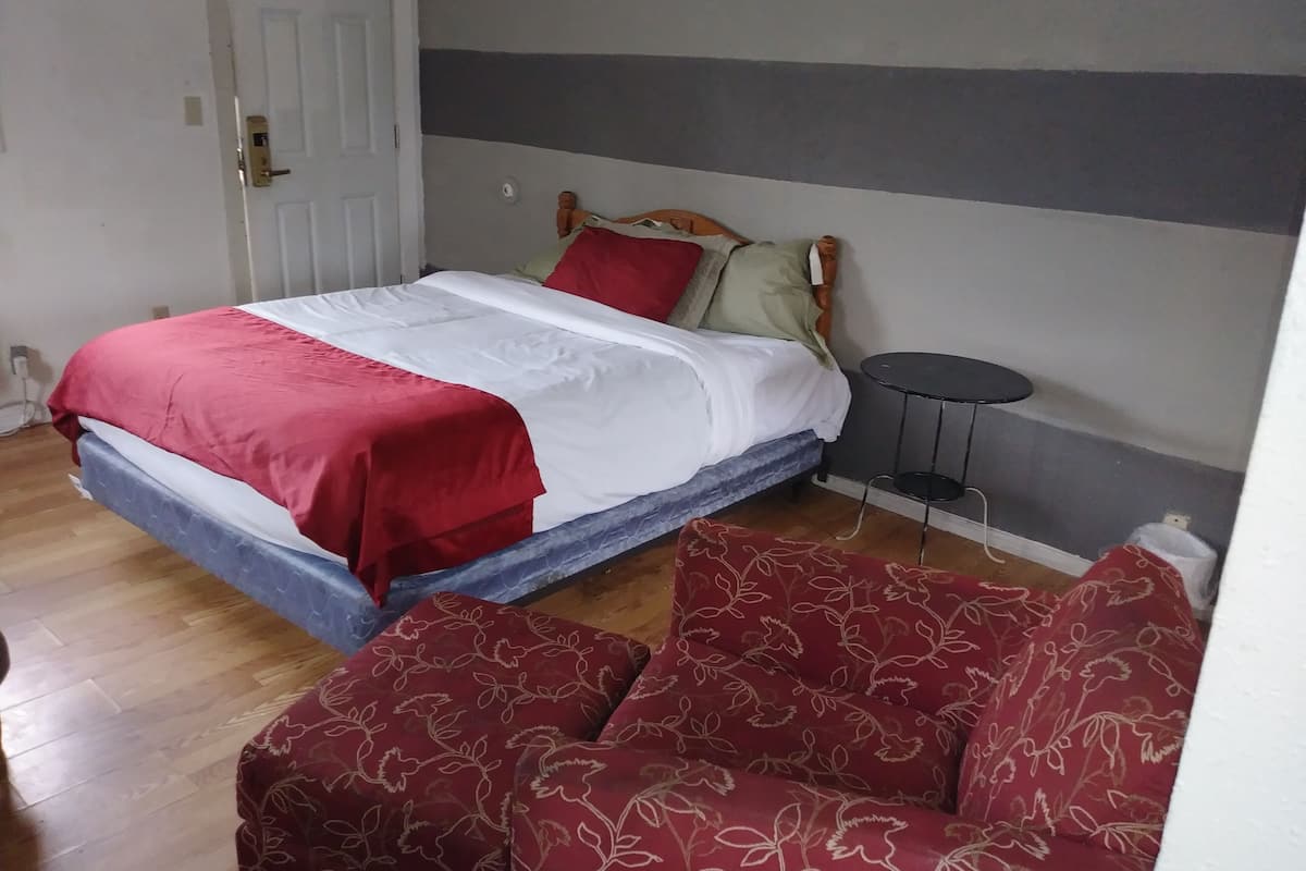 Ein Schlafzimmer mit einem Bett, einem kleinen runden Tisch und einer Couch.