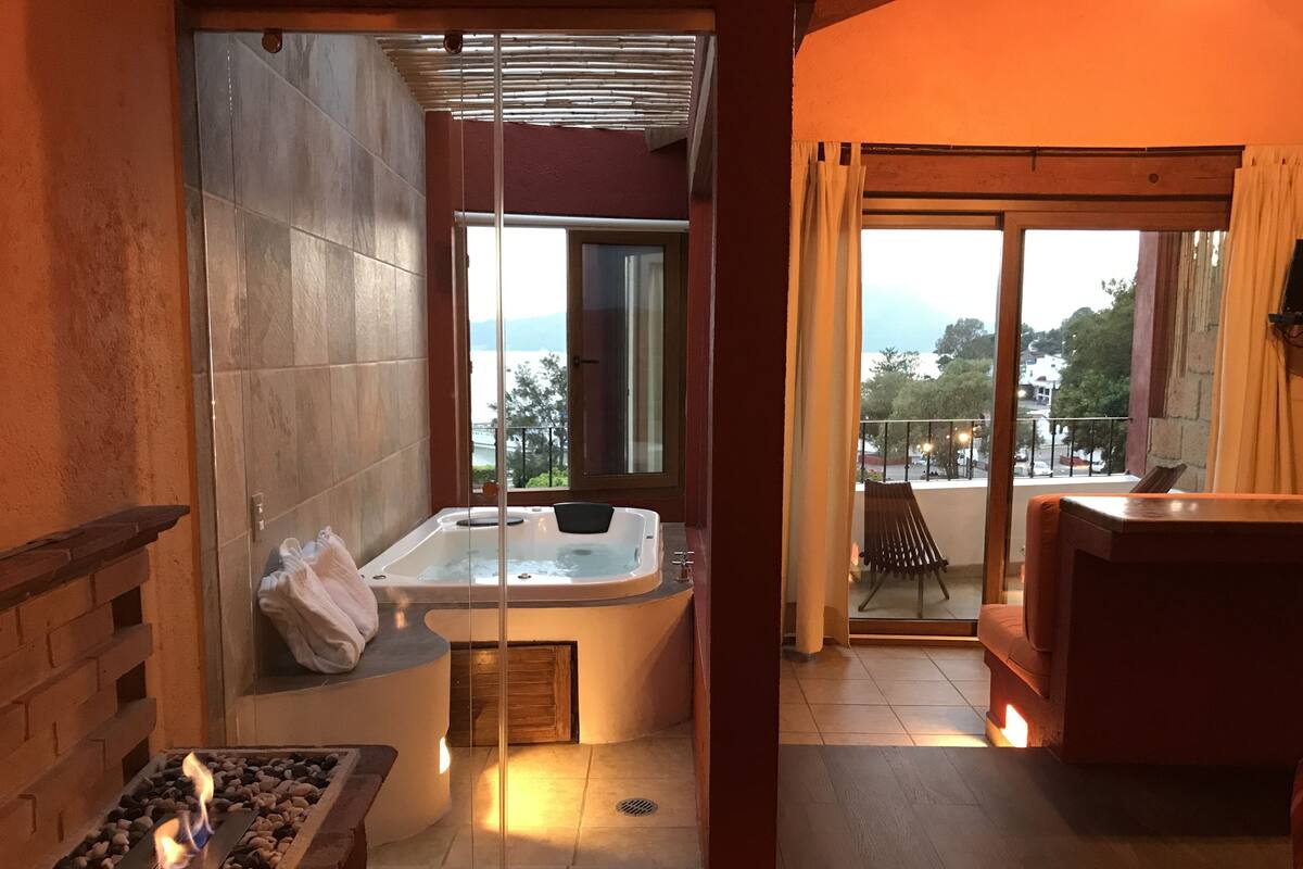 A modern bathroom with a glass-enclosed shower, a freestanding bathtub, and a fireplace.
