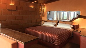 Un dormitorio acogedor con una cama de madera, una pared de ladrillo y un techo de madera.