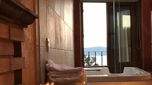 Un baño moderno con pared de piedra, chimenea y vistas a las montañas.