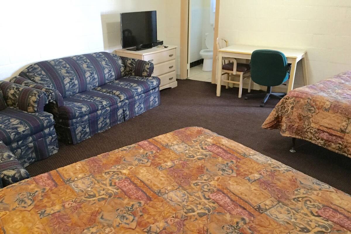 Una habitación de hotel con una cama grande, un sofá, un escritorio y una silla.