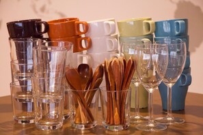 A variety of clear glass cups and wooden spoons arranged on a table. - Hostel Mitsuwaya Osaka (Osaka)
