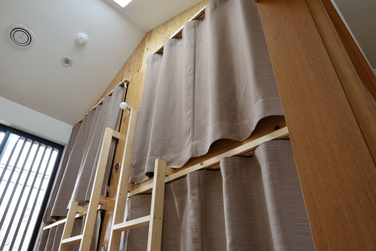 A room with a wooden ladder and curtains.