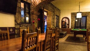 A room with a billiards table, wooden chairs, and a fireplace. - Hotel Casa de Vino (Tequisquiapan)