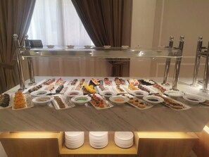 Un bufé con diversos platos y postres.