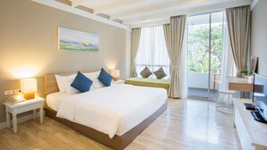 Une chambre d’hôtel avec un grand lit, des lampes de chevet, un bureau avec un ordinateur et une vue sur la verdure par la fenêtre.