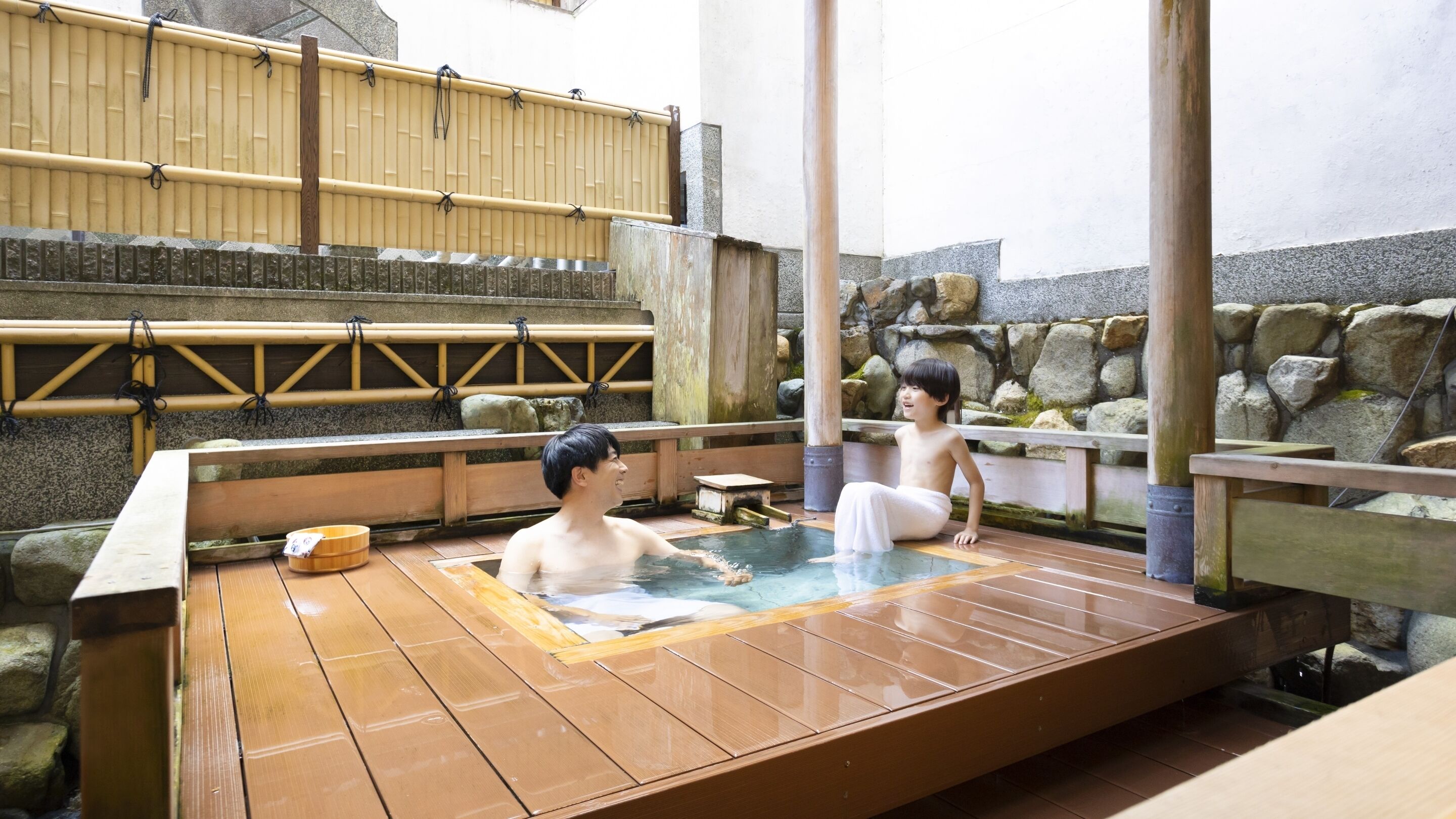 A traditional Japanese onsen with wooden benches and stone walls.