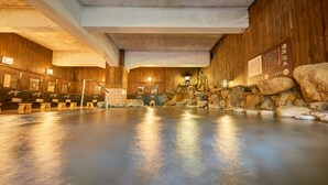 A spa area with wooden walls, a stone fountain, and multiple hot tubs. - Ooedo Onsen Monogatari Terunoyu (Maniwa)