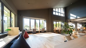 Un bureau spacieux et moderne, doté de grandes fenêtres, d’un plancher en bois et d’espaces de détente confortables.