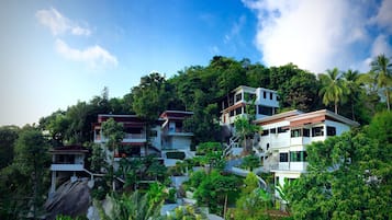 Stunning hillside homes with balconies and lush green surroundings.