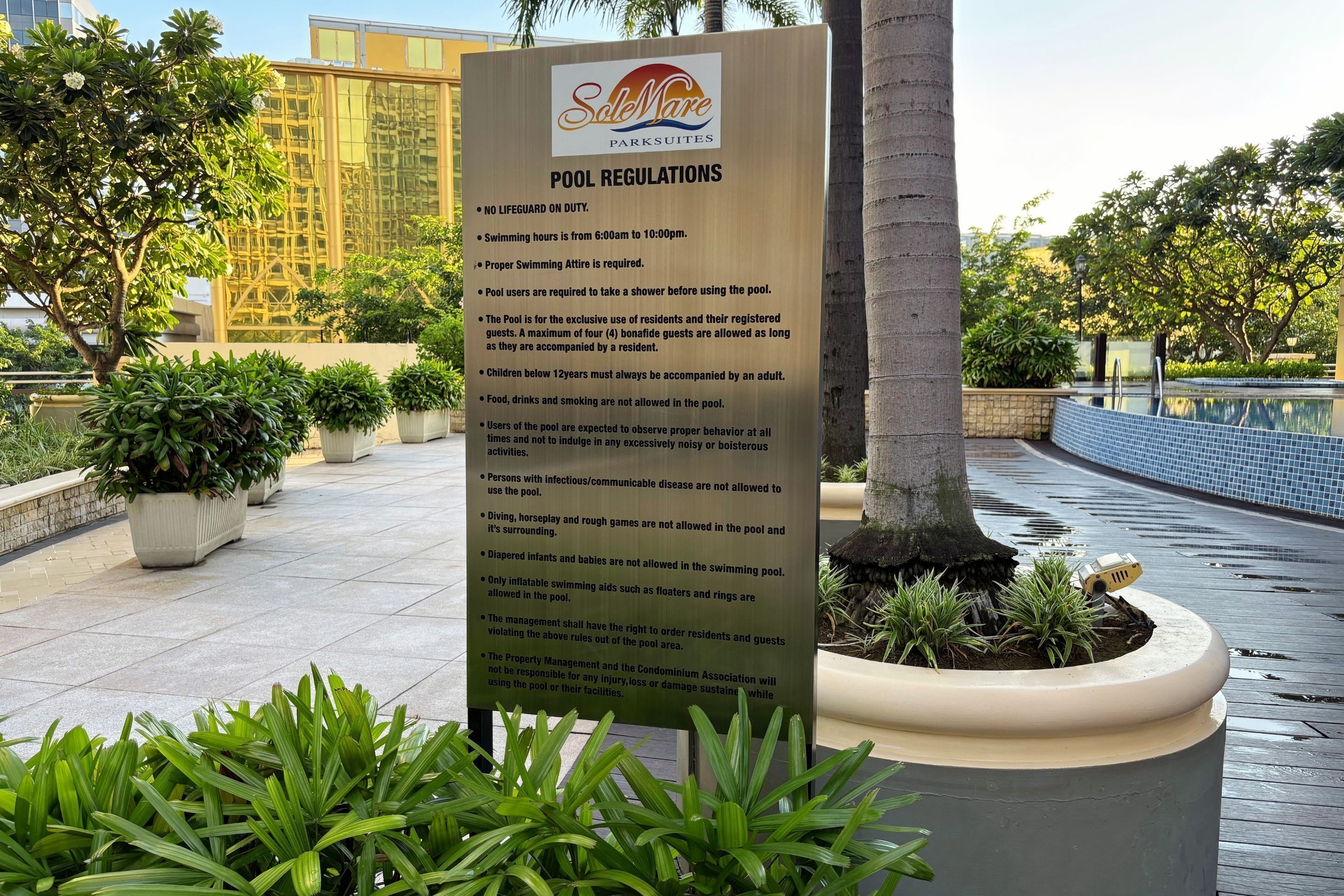 A poolside sign with pool regulations at Sole Mare Parksuites.