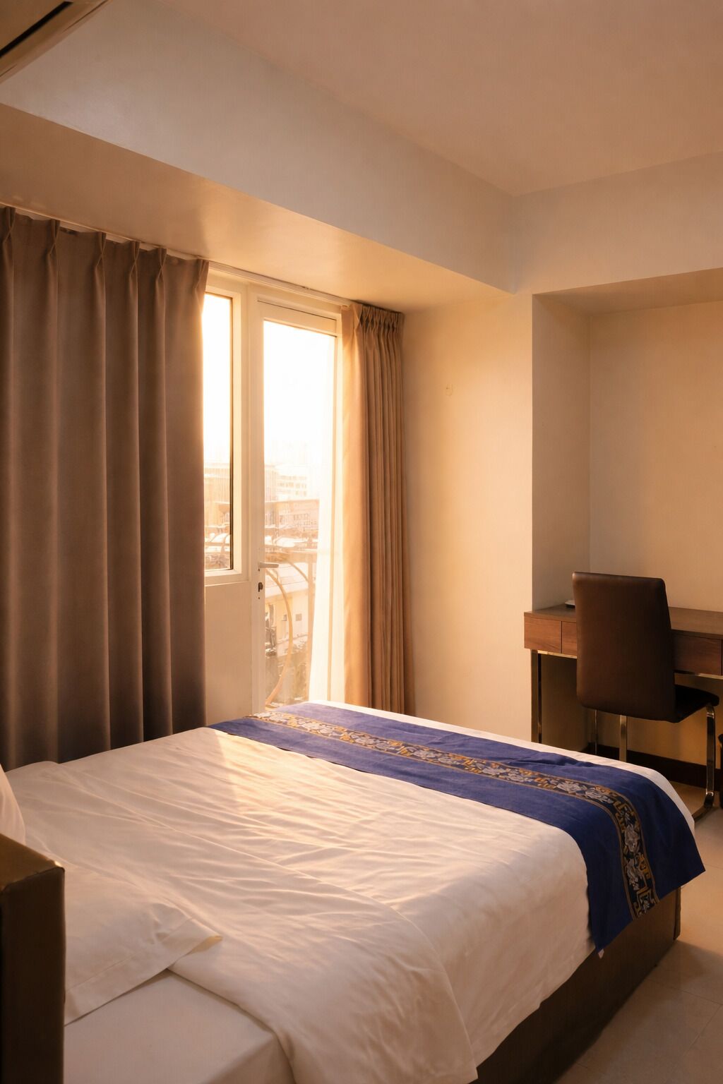 Una habitación de hotel con cama, escritorio y silla.