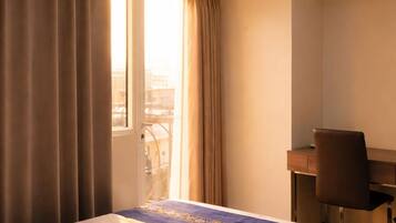 Una habitación de hotel con cama, escritorio y silla.
