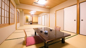 A traditional Japanese room with tatami flooring, a low table with teapot and cups, and sliding doors. - Hotel Nagisa (Beppu)
