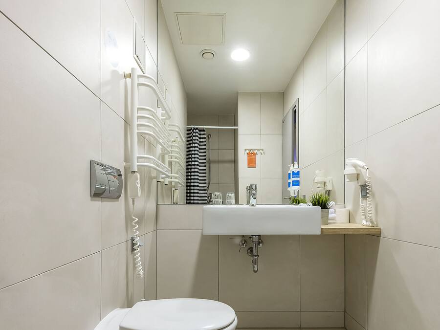 Un bagno moderno con il water, un lavandino e uno specchio.