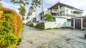 A residential street with modern houses, a paved road, and a well-maintained hedge. - Sotis Villa Canggu (Canggu)
