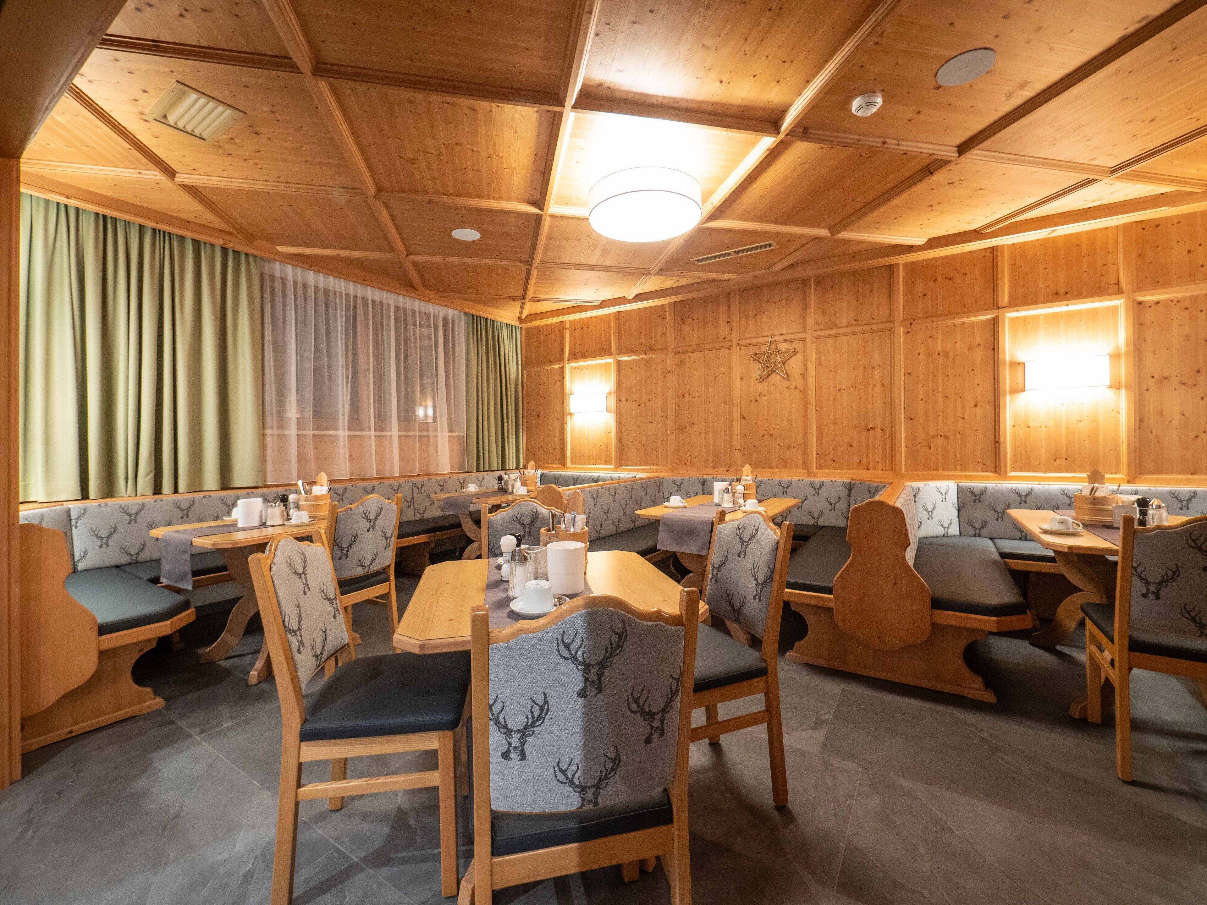 A restaurant with wooden paneling, booths, and tables.