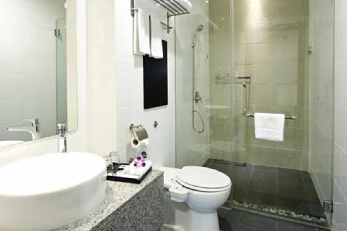 A modern bathroom with a large sink, toilet, and walk-in shower.