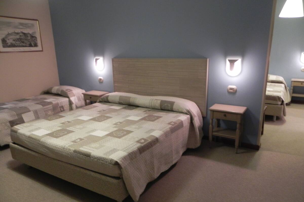 A bedroom with a large bed, two bedside tables, and a nightstand.