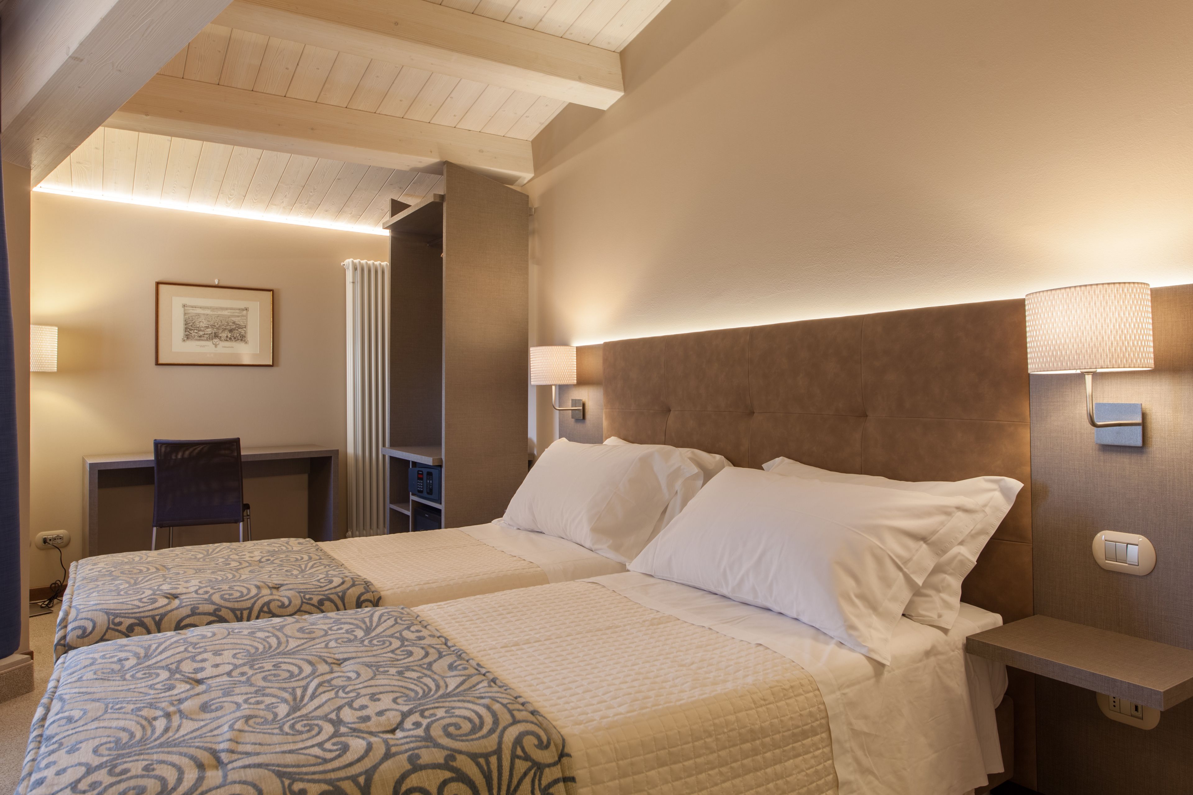 Una habitación de hotel con dos camas, un escritorio y una silla.