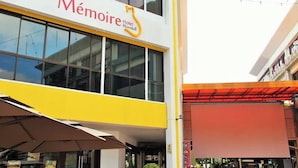 A hotel named Mémoire Hotel Hornbill with a modern facade, large windows, and a yellow accent on the lower half. - Memoire Hornbill Hotel Kuching Sarawak (Kuching)